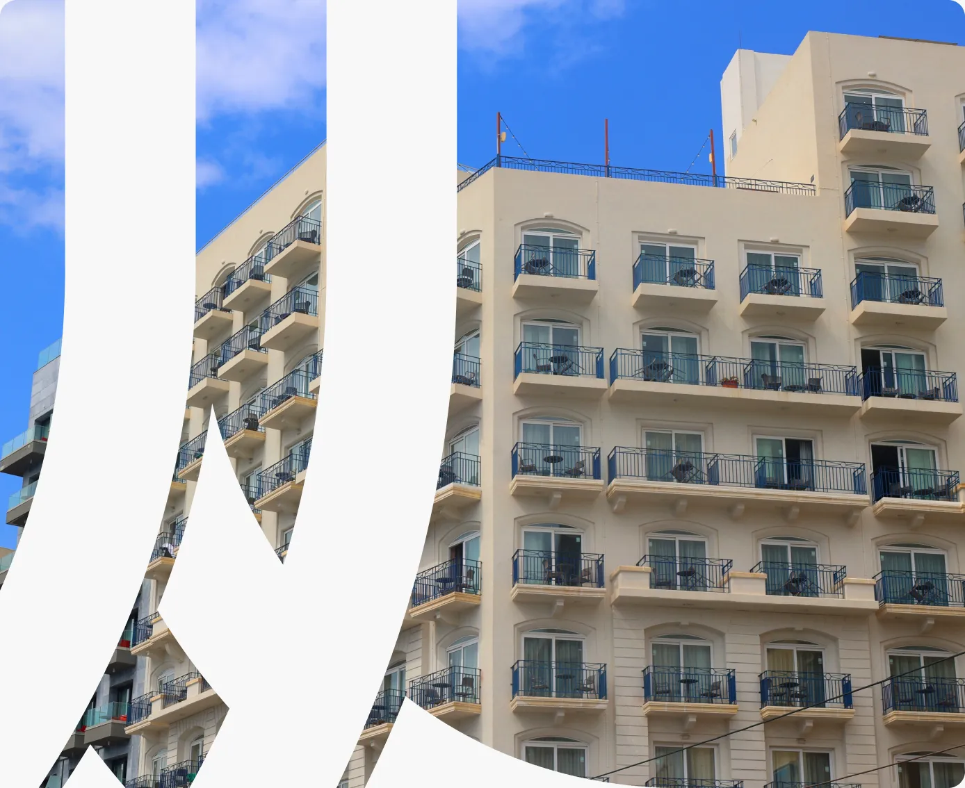 A cream-coloured apartment building with rows of balconies