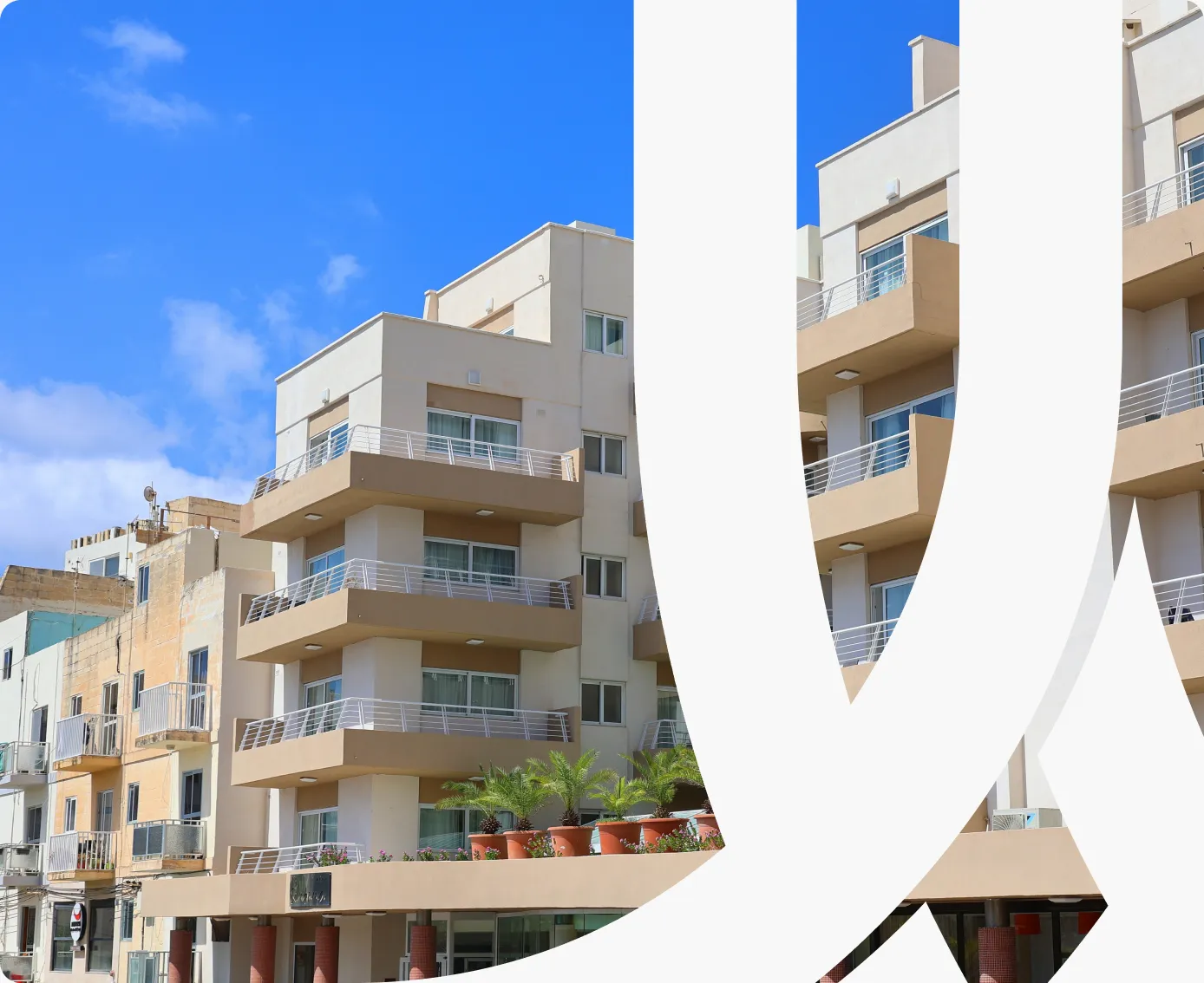 Sunlit apartment blocks with balconies against a blue sky